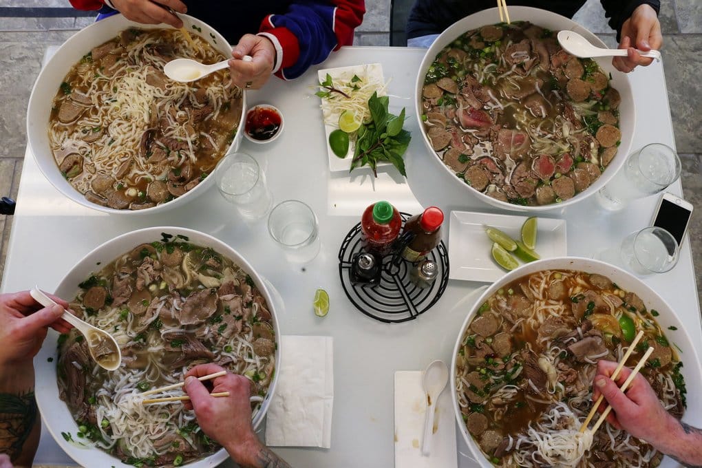 people eating pho at restaurant